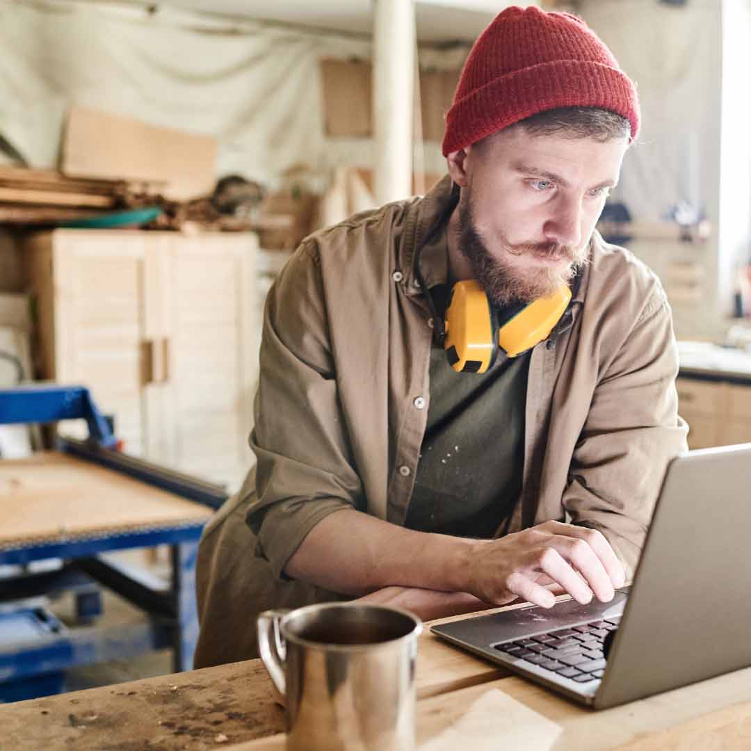 Handwerker wirkt überfordert beim Laptop – steht für digitale Herausforderungen im Handwerk