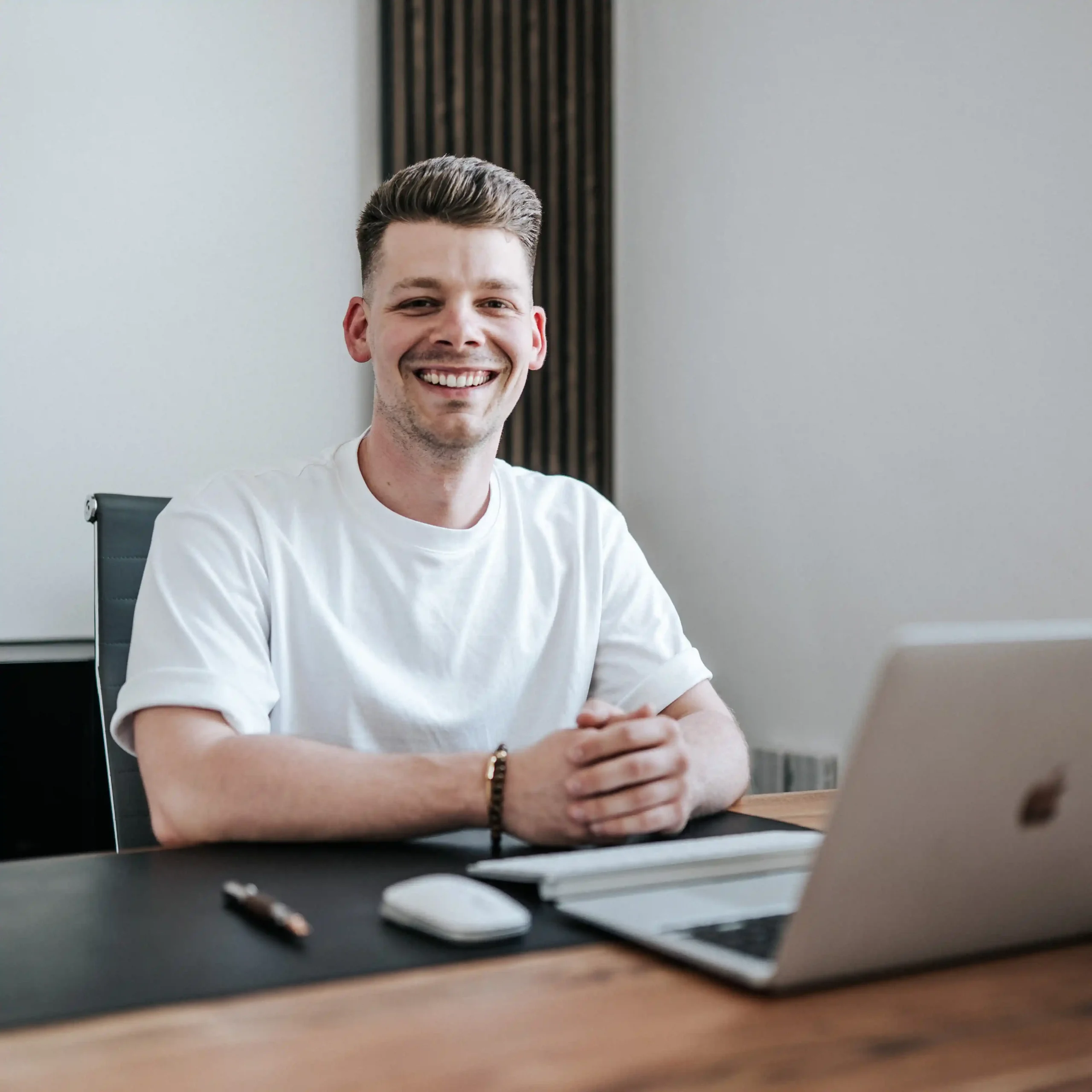 Kunden-Bewertung-von-Phillipp-Pelzer-lächelt-in-die-Kamera-sitzt-vor-Laptop-Webdesign-für-Handwerker